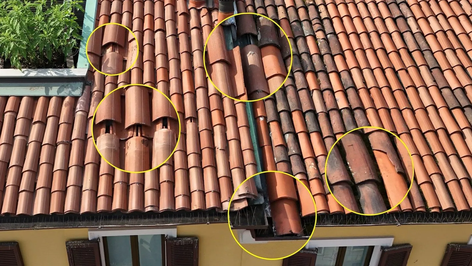 Tetto in coppi ripreso dal drone, con cinque punti critici cerchiati in giallo: coppi spostati, rotti e fuori sede